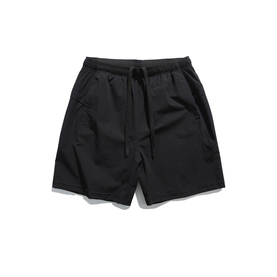 Black drawstring shorts with an elastic waistband and angled side pockets, flat lay front view
