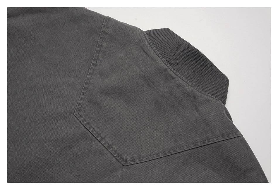 Close-up of the dark gray jacket's back yoke seam and ribbed collar.