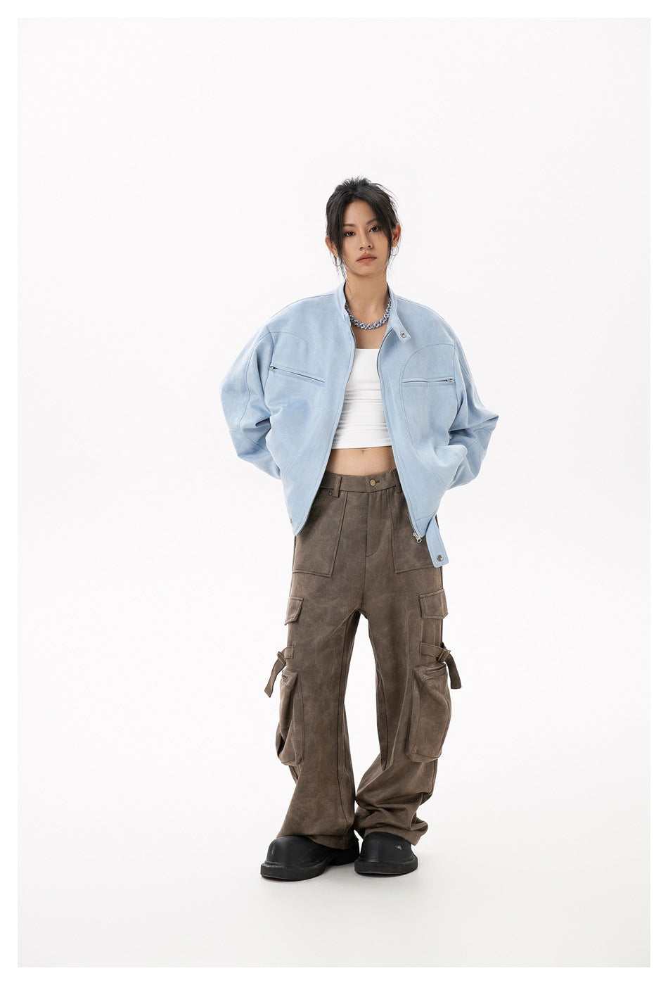 Model wearing a light blue zip-front jacket with chest pockets and a stand collar, paired with brown cargo pants.