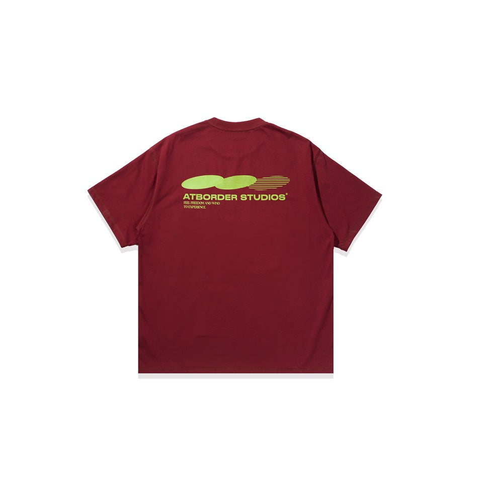 Flat view of the back of a burgundy T-shirt with a yellow-green graphic and text across the upper back.