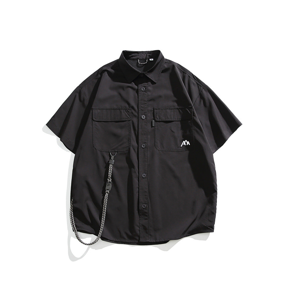 Black short-sleeve button-up shirt with two flap chest pockets, mountain logo and a hanging cord, flat lay front view