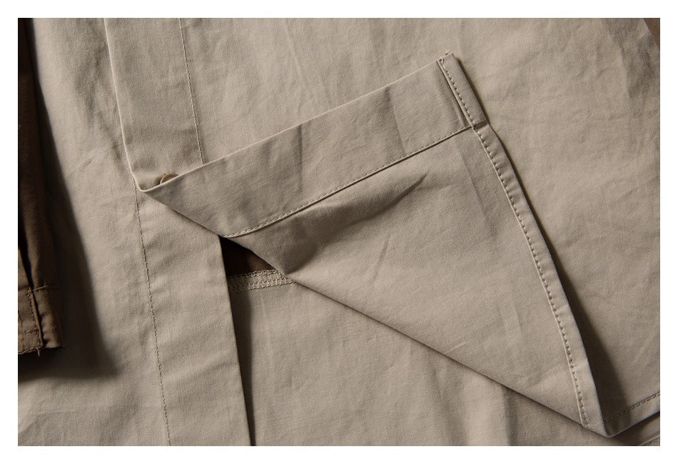 Close-up of a light taupe garment pocket with its flap lifted to reveal the opening.