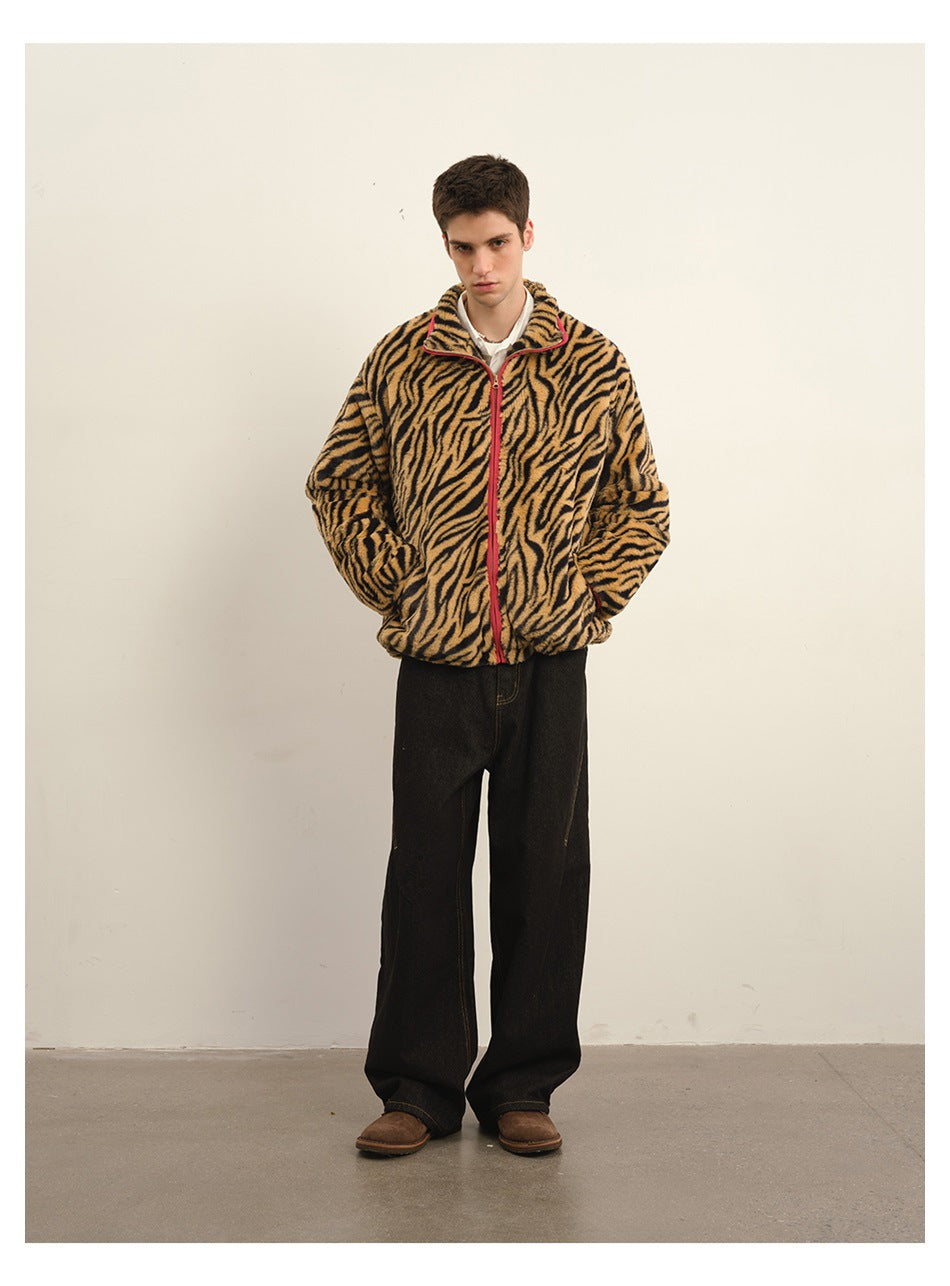 Full-length front view of a man in a tan-and-black tiger-stripe zip jacket with pink-red trim and wide black pants.