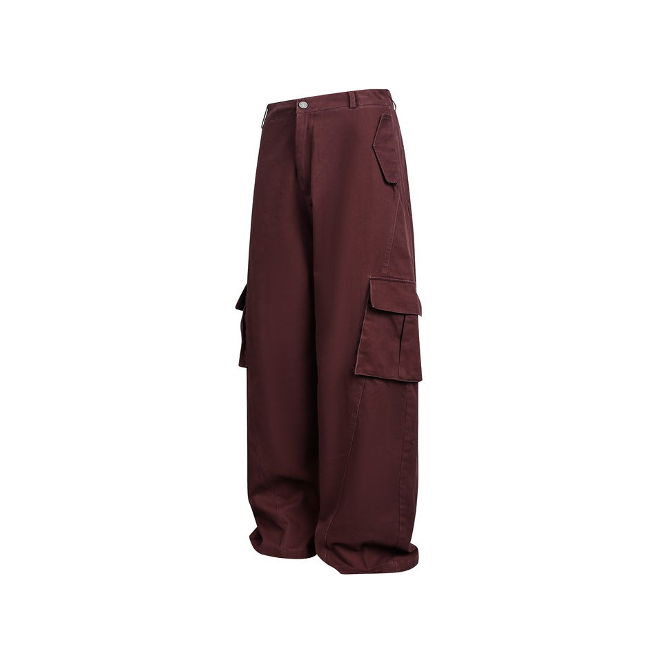 Angled side view of loose burgundy cargo trousers showing the large flap thigh pocket.