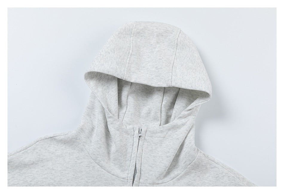 Close-up of a light heather-gray hoodie showing its hood and upper front zipper.