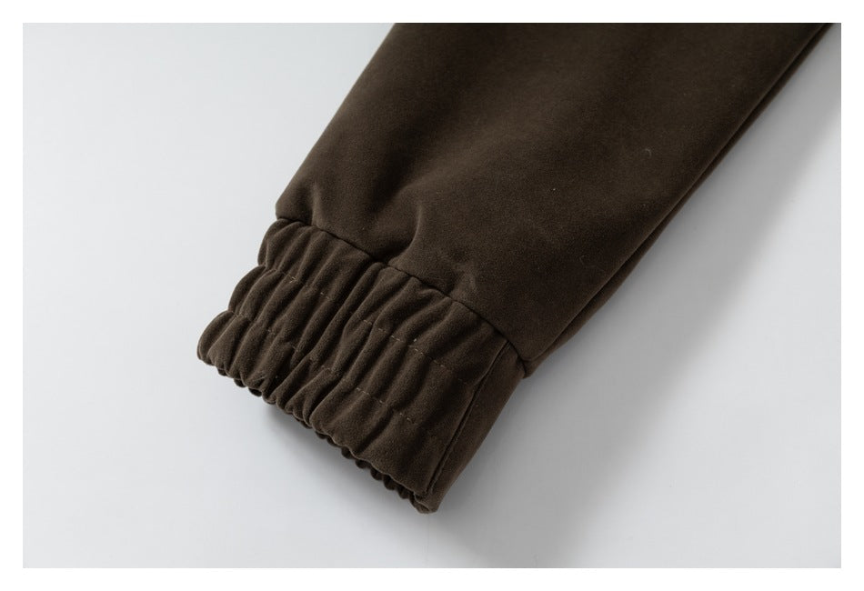 Close-up of a dark brown jacket sleeve ending in a gathered cuff.