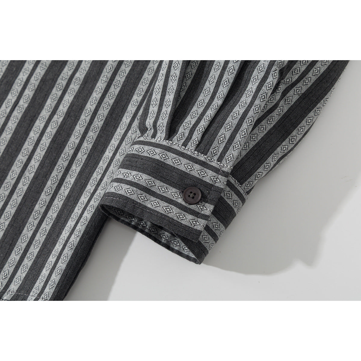 Close-up of the charcoal gray shirt's long sleeve and buttoned cuff with diamond-patterned stripes.
