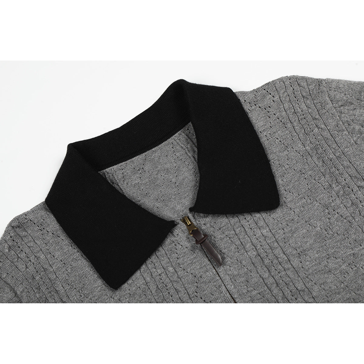 Close-up of a gray knit top’s black collar and short front zipper.