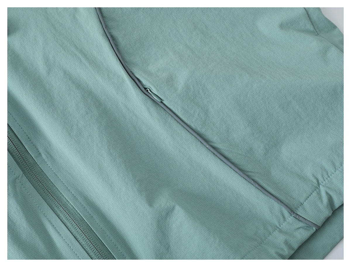 Close-up of a pale teal jacket panel with a diagonal piped seam and zipper edge.