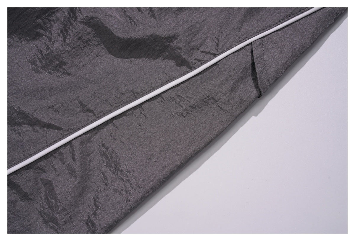 Close-up of white piping along a seam on the charcoal gray pants.