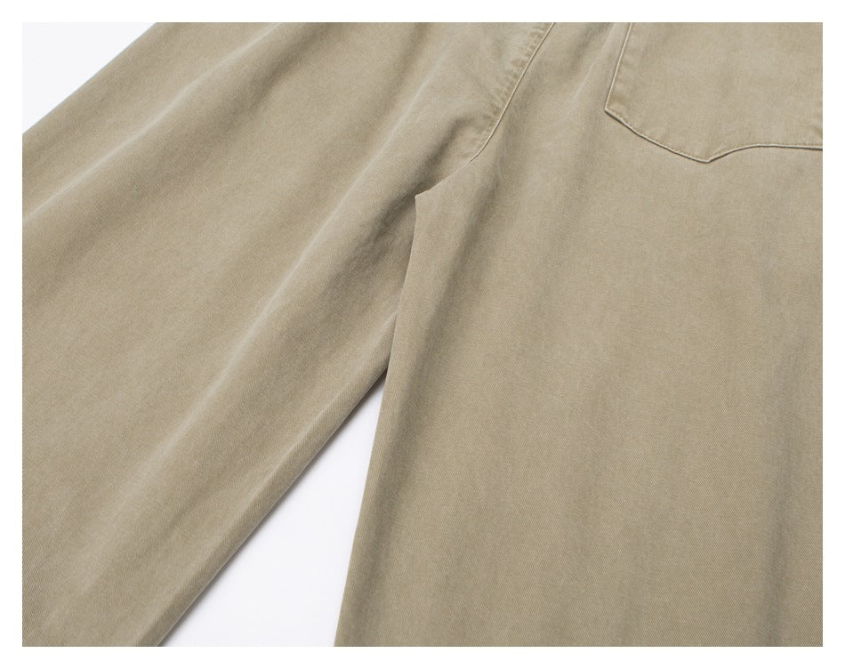 Close-up of tan trousers showing a curved pocket seam and adjacent leg fabric.