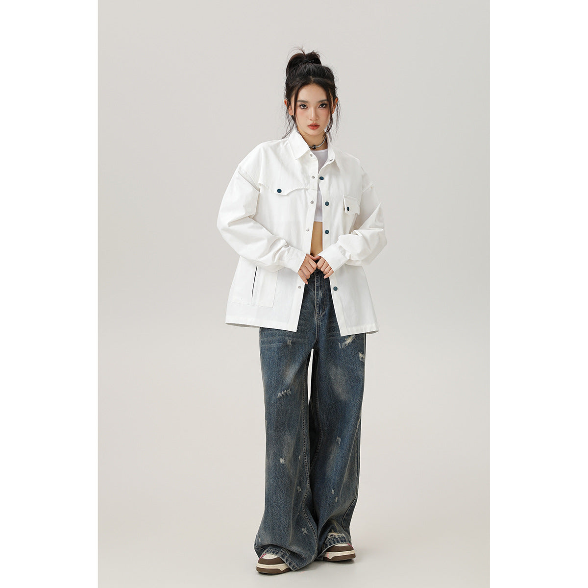 Model wearing a white oversized button-front shirt with flap chest pockets and lower patch pockets.