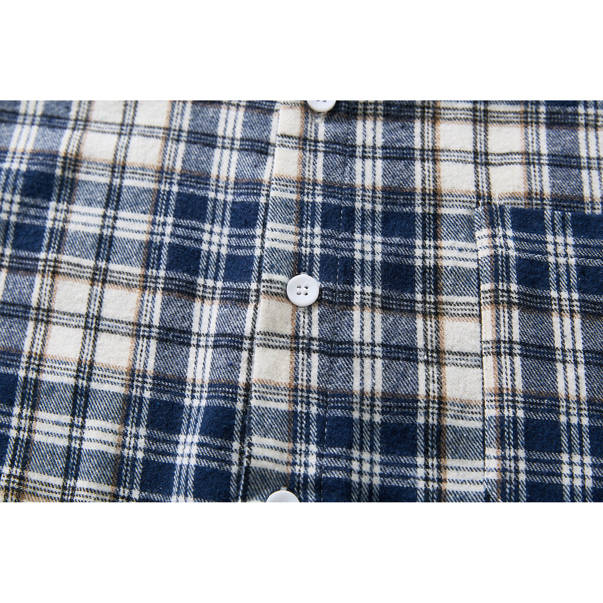 Close-up of navy, cream, and beige plaid shirt fabric with white buttons.