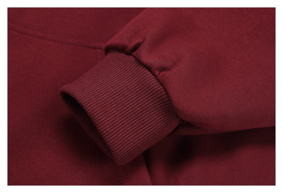 Close-up of the burgundy hoodie’s ribbed sleeve cuff and seam.
