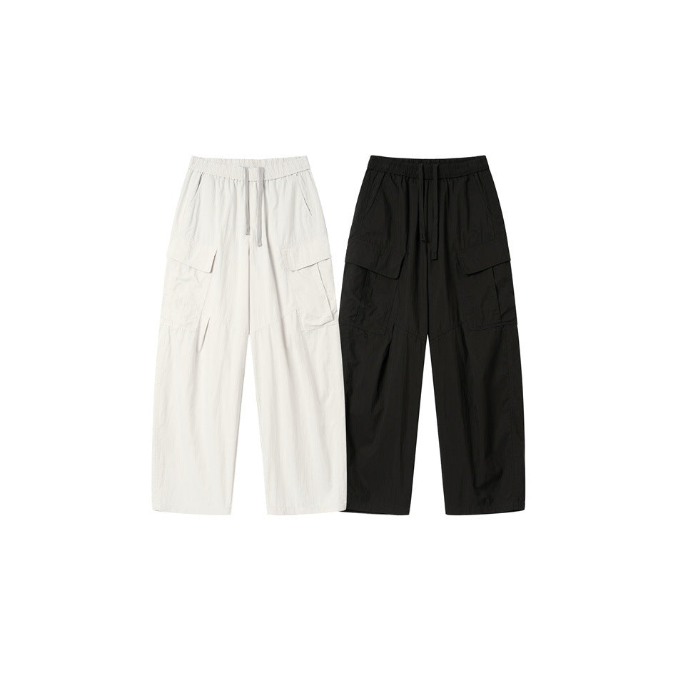 Front view of wide-leg cargo pants in white and black, each with an elastic drawstring waist and flap pockets.