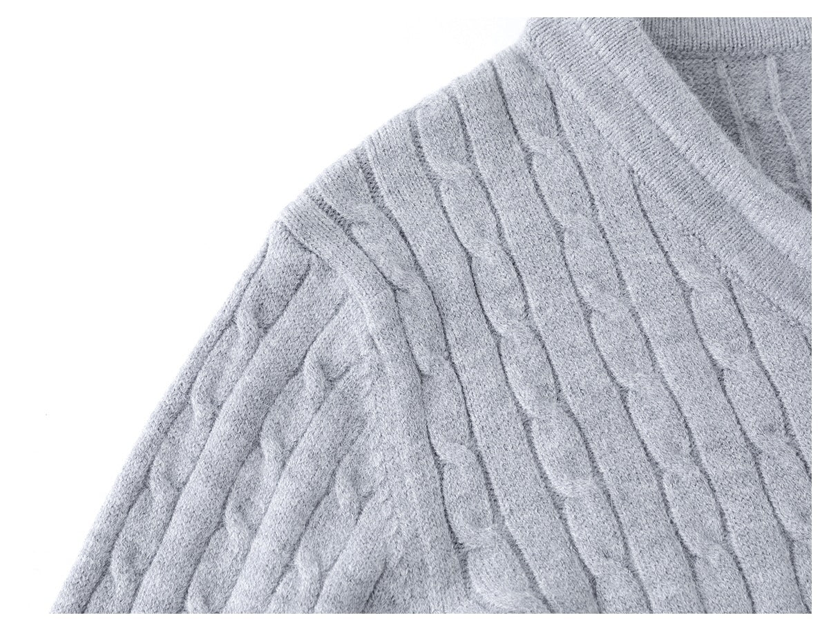 Close-up of the light gray cable-knit garment's shoulder and neckline.