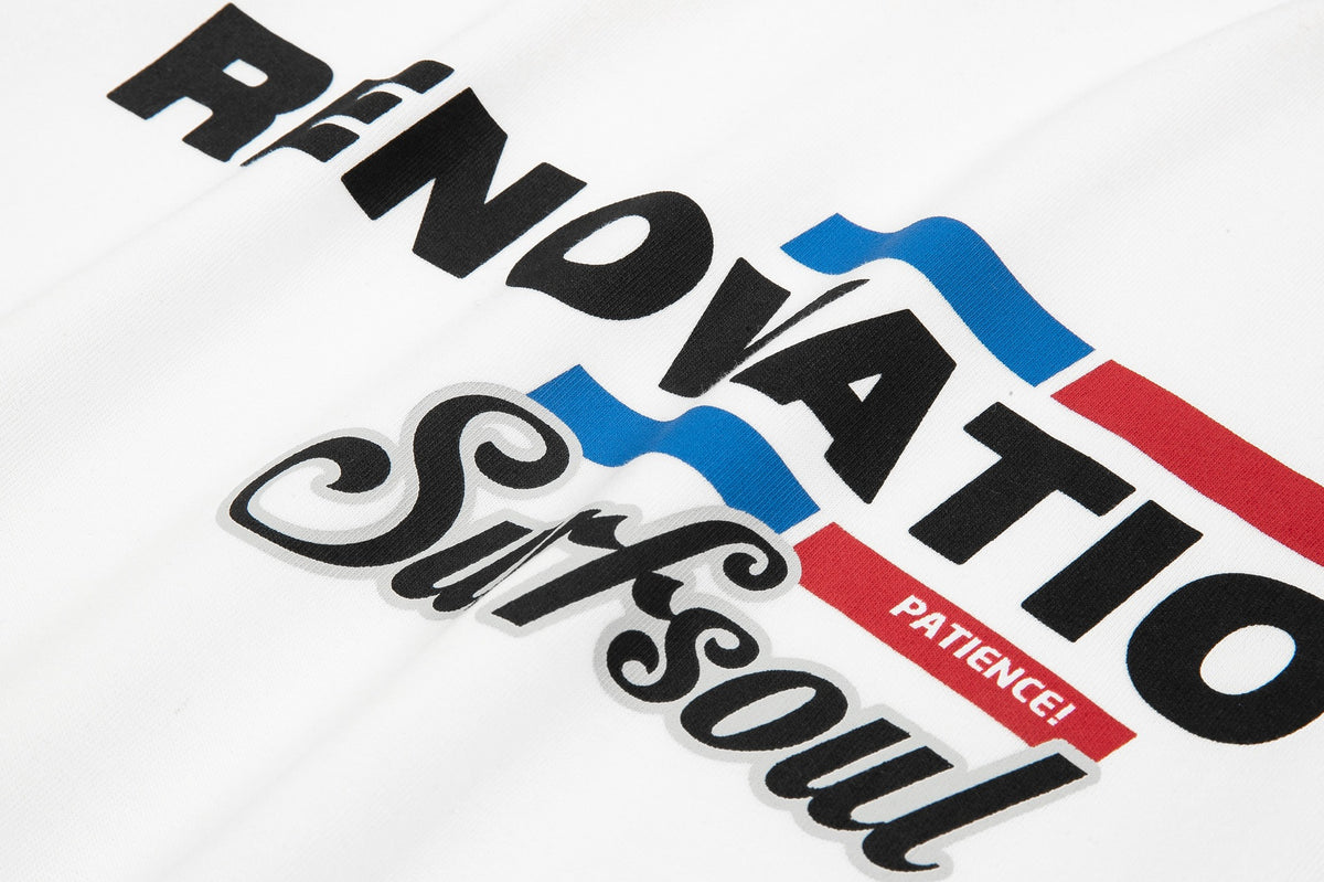 Close-up of a white T-shirt graphic with bold black lettering, blue and red accents, and decorative script.