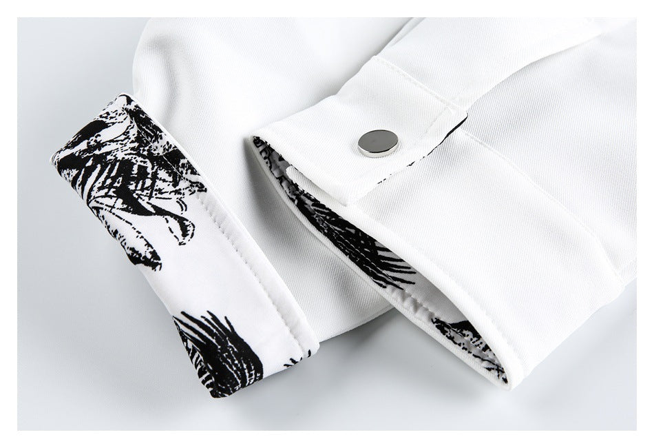 Close-up of a white garment cuff with a metal snap and black-and-white printed lining.