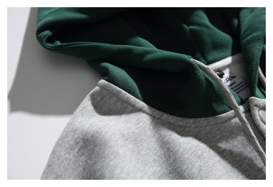 Close-up of the dark green hood lining, gray neckline seam, and drawstring on the hoodie.