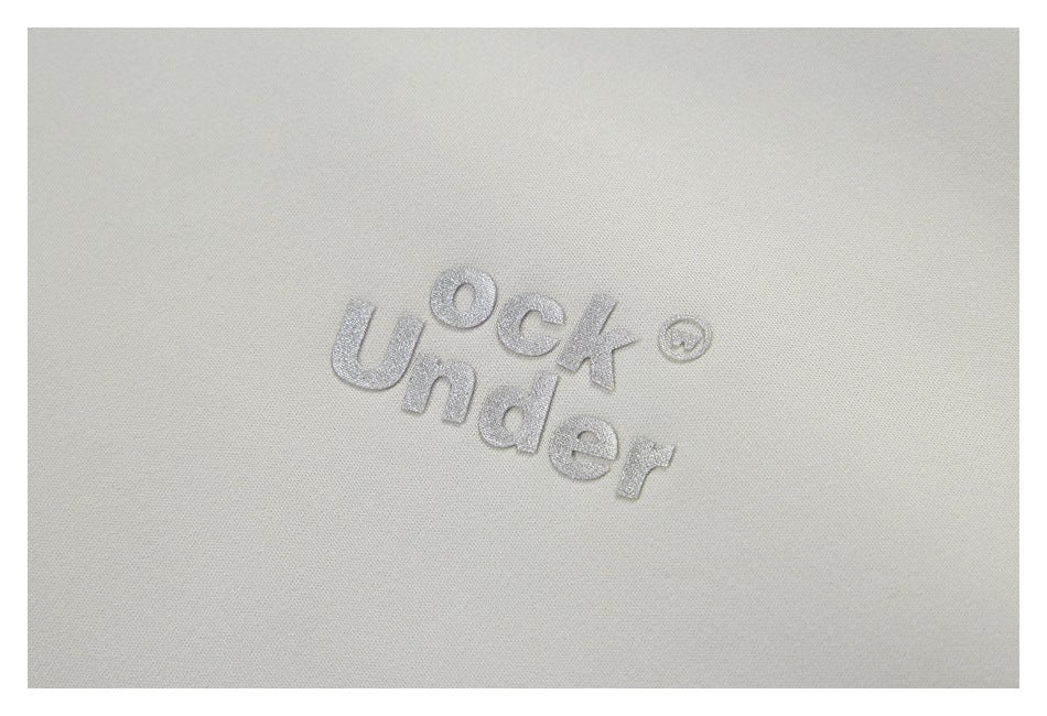 Close-up of a small silver embroidered wordmark on light gray fabric.
