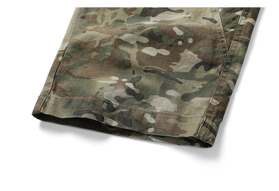 Close-up of the hem and side seam of green-brown camouflage trousers against a white background.