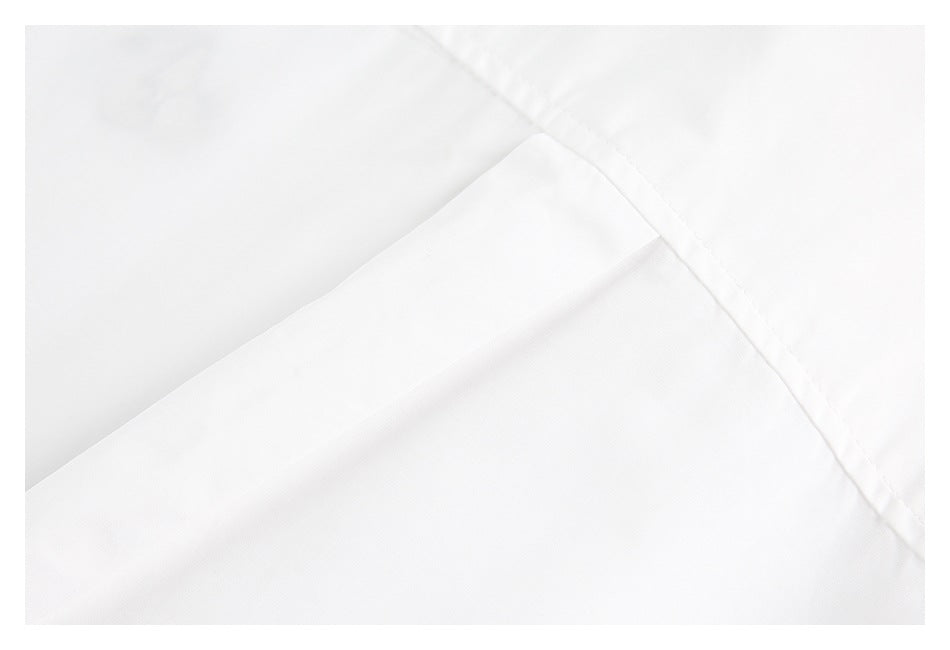 Close-up of a folded white garment panel and stitched seam.