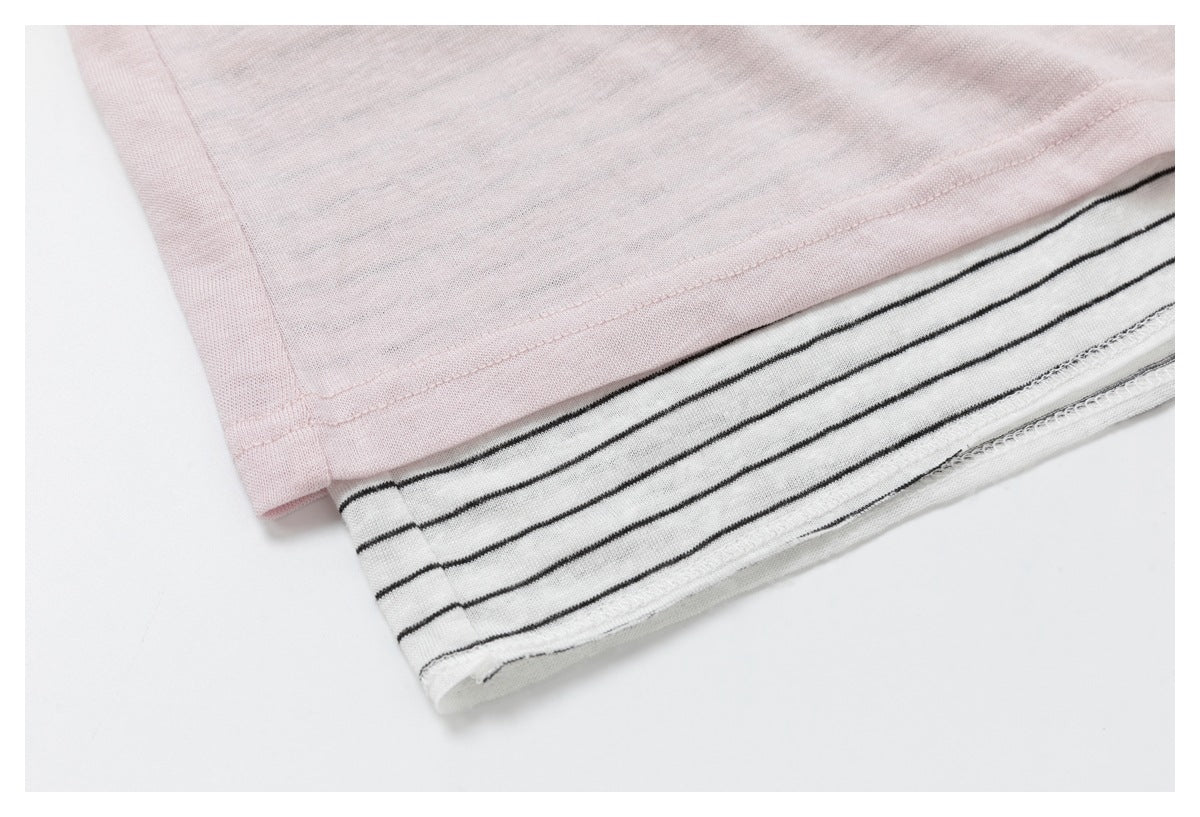 Close-up of the layered hem, with pale pink fabric over a white, black-striped underlayer.
