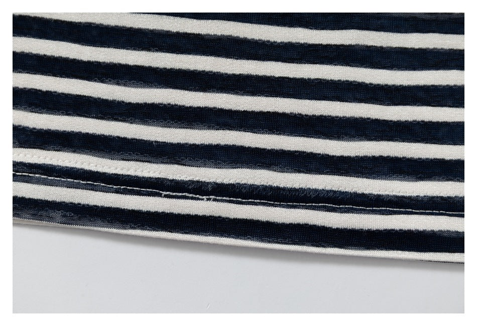 Close-up of stitching along the hem of navy and cream striped fabric.