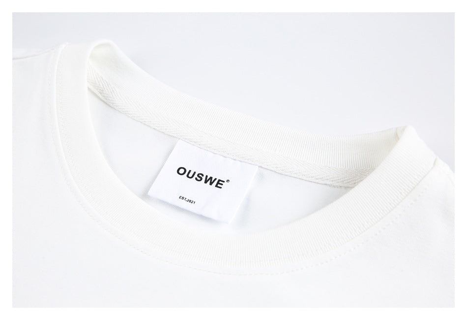 Close-up of the white T-shirt’s ribbed crew neckline and sewn-in OUSWE label.