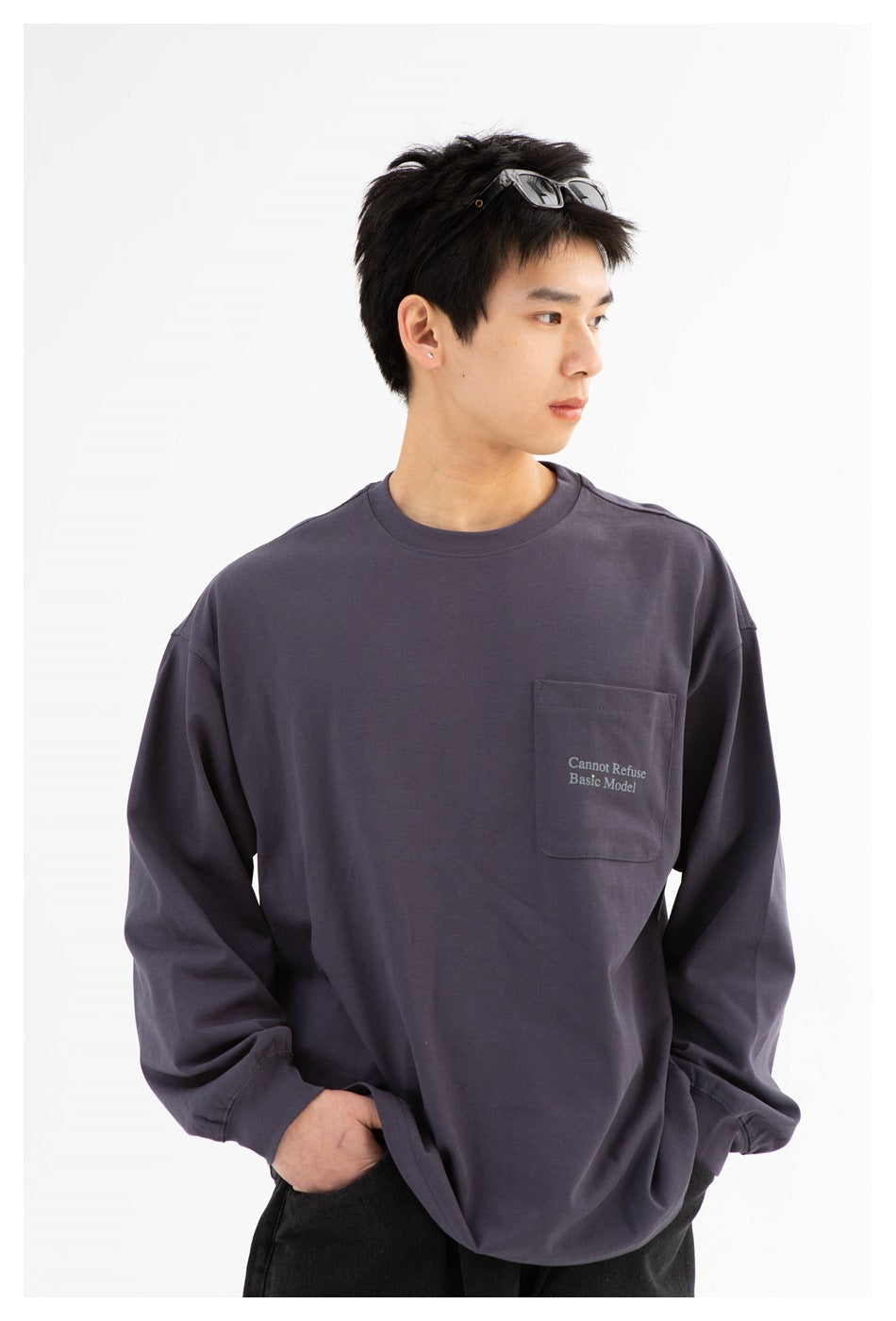 Front view of a model wearing a charcoal-gray long-sleeve sweatshirt with a chest pocket and small English text.