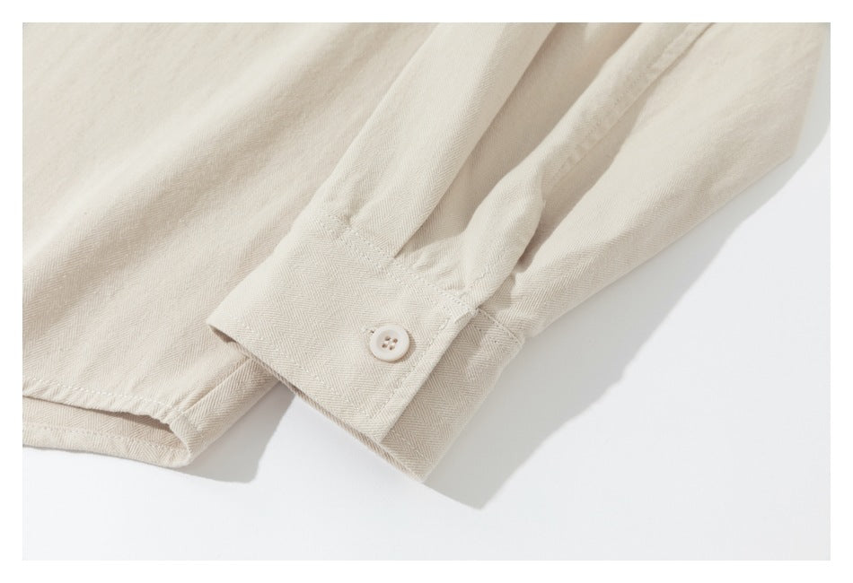 Close-up of a cream shirt sleeve cuff with a small off-white button.