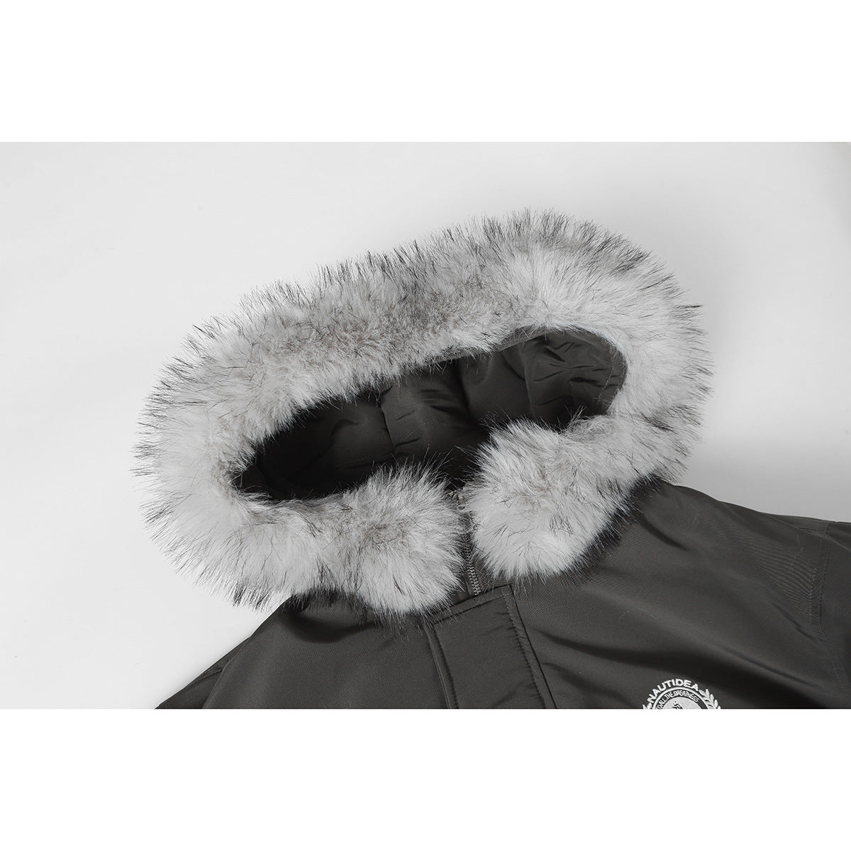 Close-up of a charcoal jacket hood edged with thick light gray faux fur.