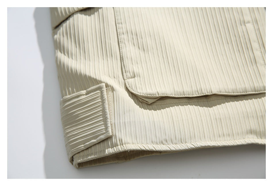 Close-up of an ivory ribbed jacket pocket flap, hem, and cuff tab.