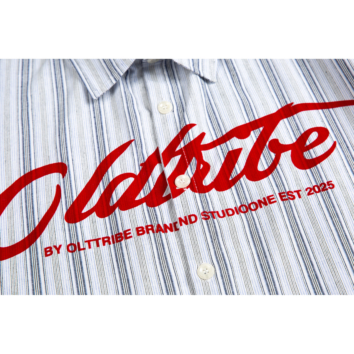 Close-up of a white shirt with fine blue-gray stripes, white buttons, and a large red script chest print.