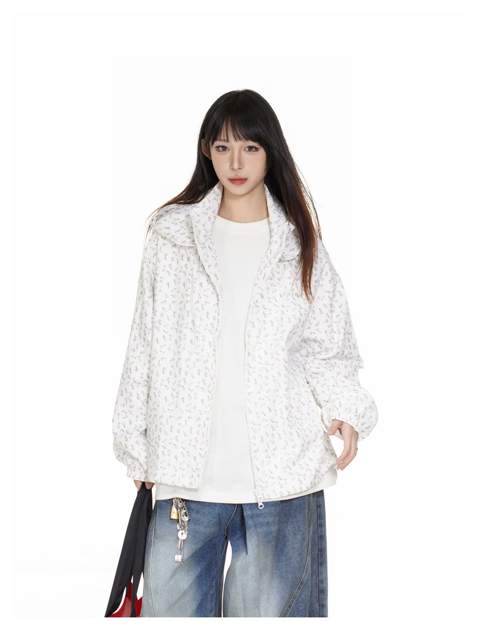 Closer front view of a model wearing an open white floral-print hooded jacket over a white top.