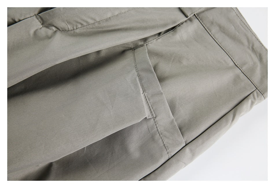 Close-up of the taupe-gray trousers' rear pocket and surrounding seams.