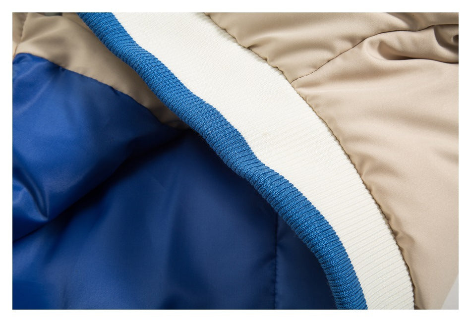 Close-up of a beige jacket with blue lining and a white ribbed band edged in blue.