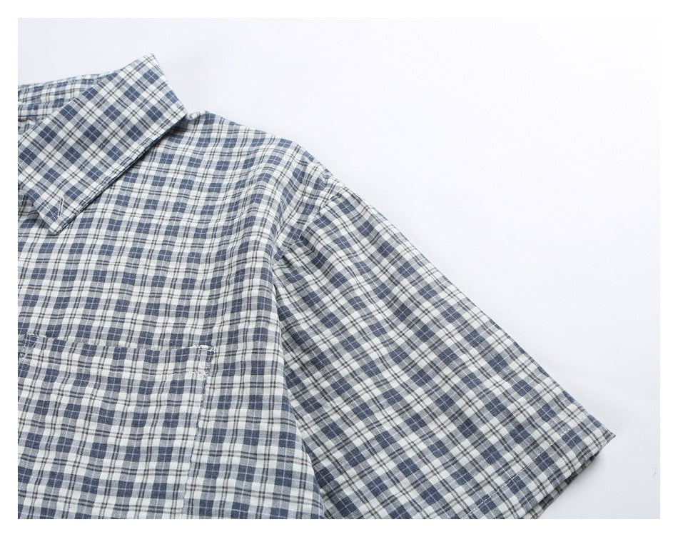 Close-up of the blue-gray plaid shirt's shoulder, short sleeve, collar edge, and chest pocket.