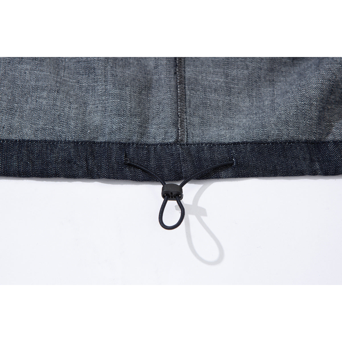 Close-up of the jacket's dark hem and black adjustable drawcord toggle.