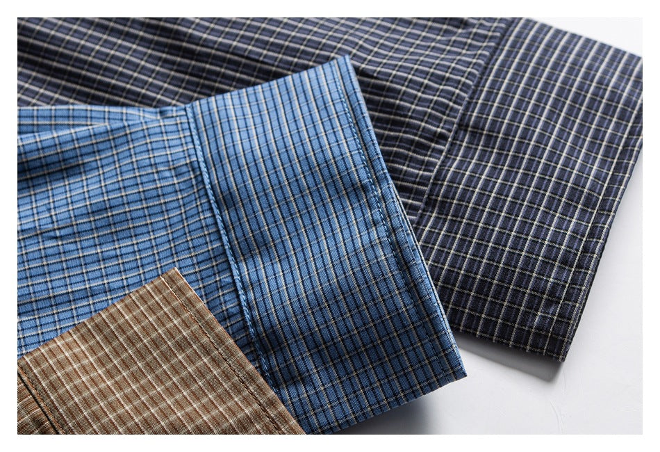 Close-up of blue, brown, and dark charcoal checked shirt fabrics arranged together.
