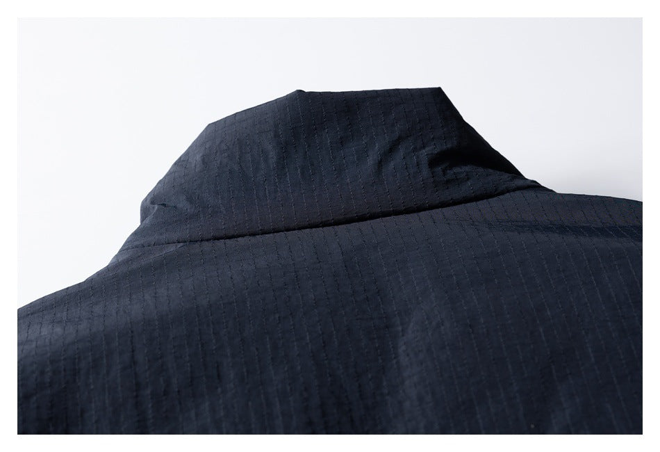 Close-up of the dark navy jacket's back collar and upper back, showing subtle vertical texture.