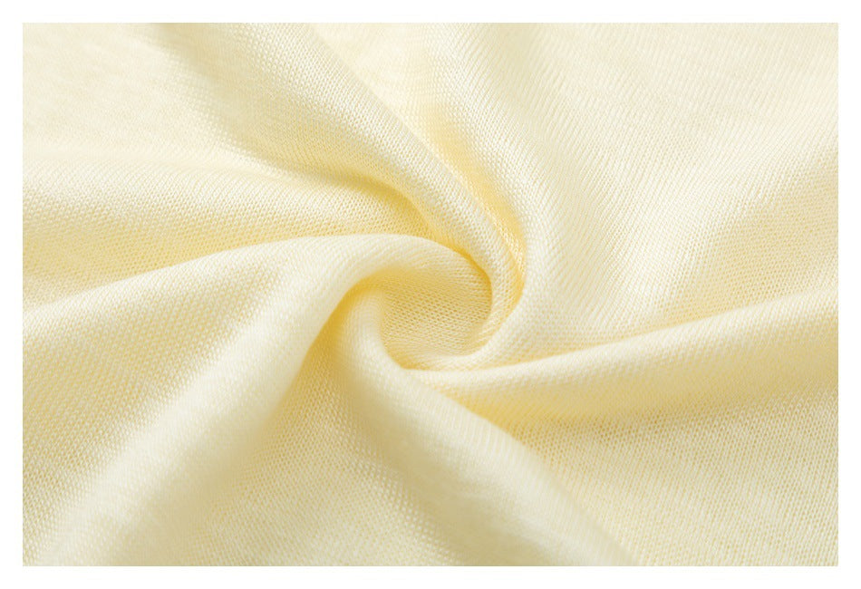 Close-up of pale yellow fabric gathered into a swirl, showing its knit texture.