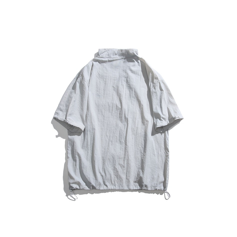 Light gray short-sleeve jacket laid flat, showing a high collar, plain back, and adjustable drawcord hem.
