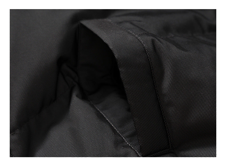 Close-up of a black fabric panel with a wide stitched strap or loop.