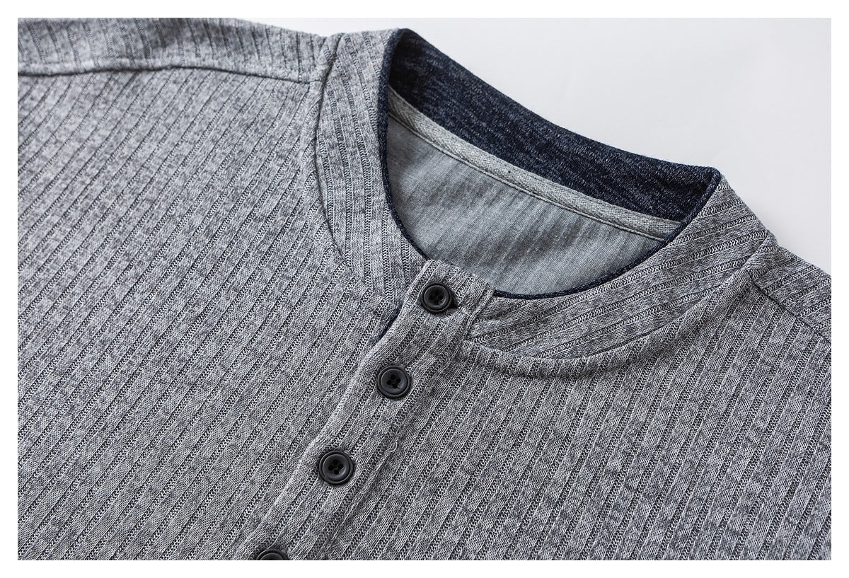 Close-up of a gray ribbed shirt's band collar and dark four-button placket.