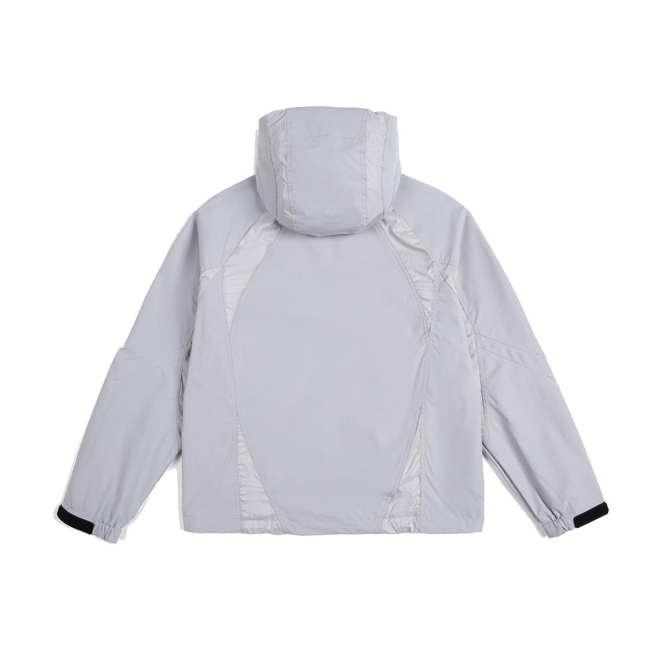 Rear view of a pale gray hooded jacket with light contrast panels and black cuff tabs.