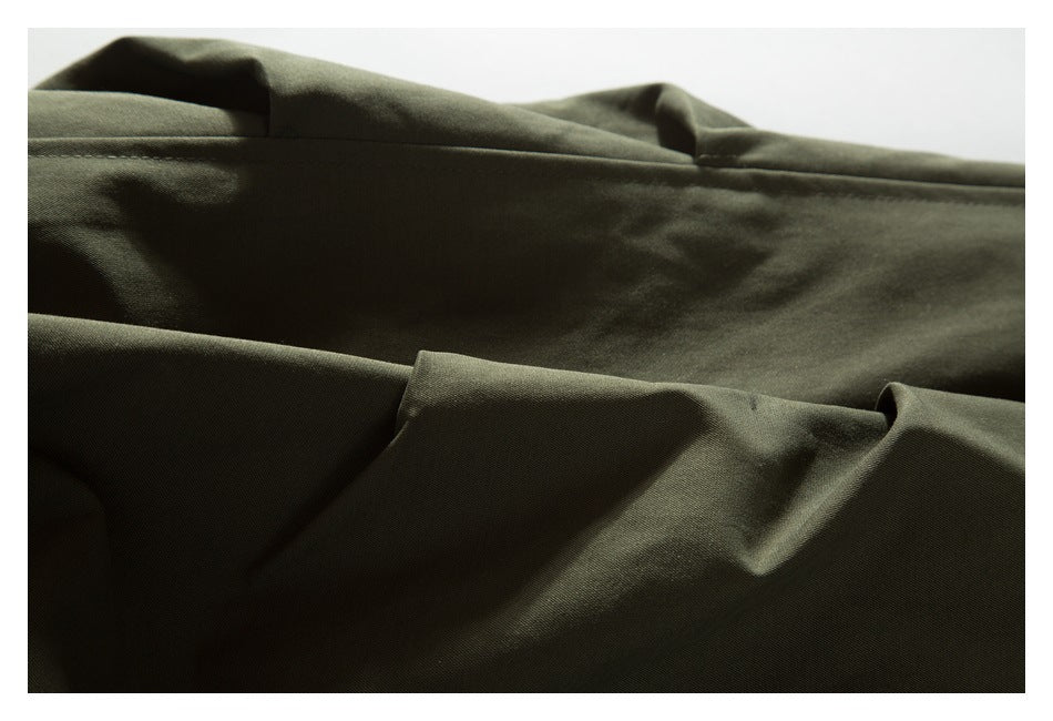 Close-up of the olive jacket's back panel and stitched seam.