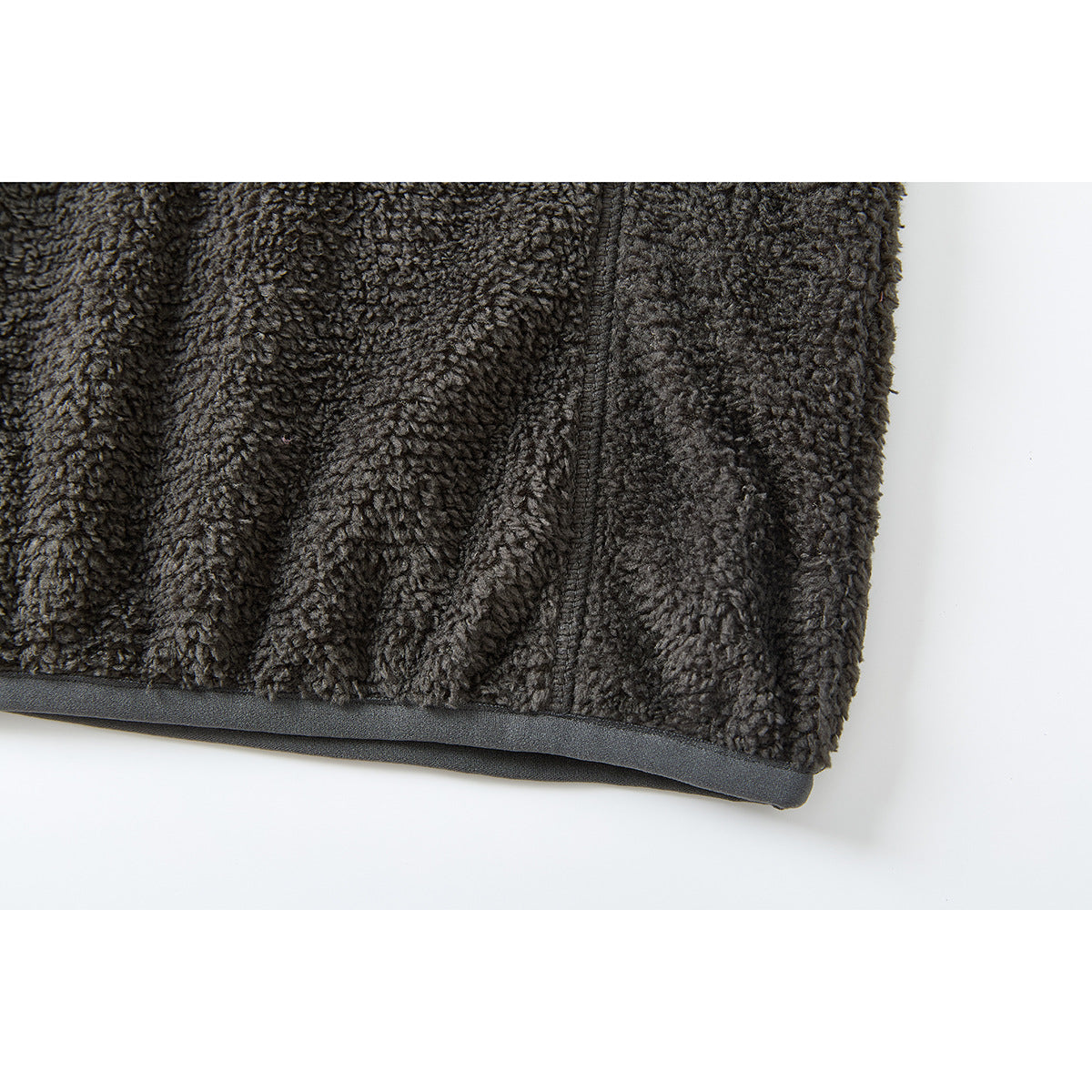 Close-up of the charcoal fleece pullover's lower hem and dark edge binding.