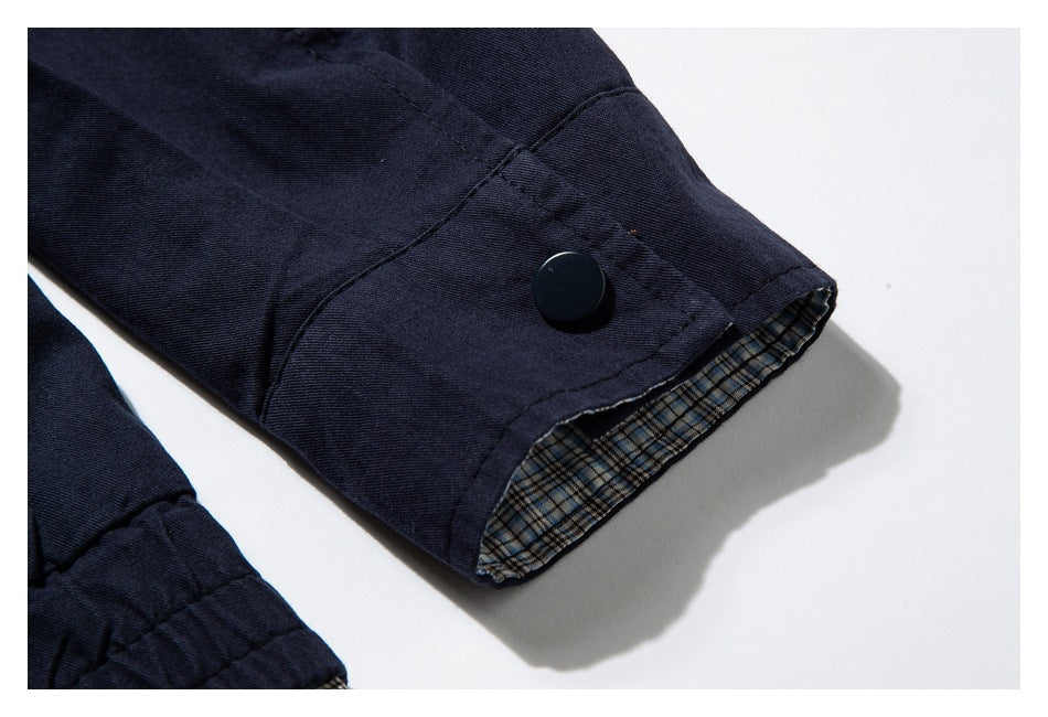 Navy sleeve cuff with a dark snap button and blue-and-tan plaid lining.