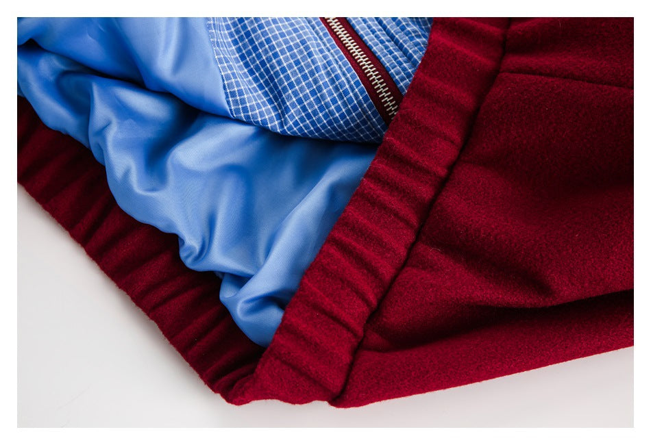 Close-up of a burgundy garment with a blue lining and blue-and-white checked inner trim.